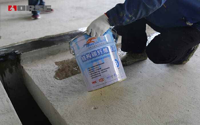 Applying carbon fiber impregnating adhesive for CFRP strengthening Applying carbon fiber impregnating adhesive for CFRP strengthening